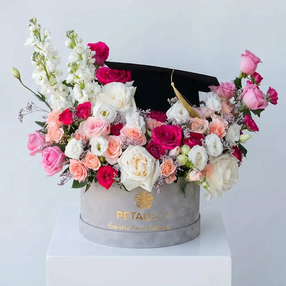 graduation flower box with mixed roses and seasonal blooms, luxury floral arrangement with graduation cap card, premium gift by Petal Box UAE for delivery in Abu Dhabi and Dubai